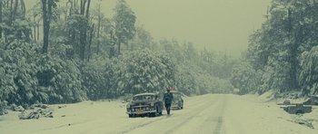 Movie still from “On the Road” (2012), directed by Walter Salles – A man walking down a snow covered road next to a car; Extreme Wide shot, Low angle