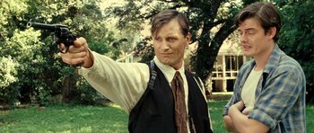 Movie still from “On the Road” (2012), directed by Walter Salles – A man in a vest and tie holding his arm up in the air; Close Up shot, Low angle