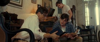 Movie still from “On the Road” (2012), directed by Walter Salles – A man reading a book to two other men; Medium shot, Over the shoulder angle
