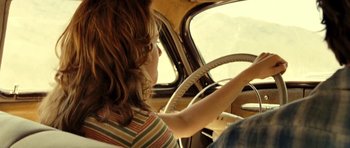 Movie still from “On the Road” (2012), directed by Walter Salles – A woman driving a car in a vehicle; Close Up shot, Over the shoulder angle