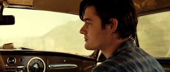 Movie still from “On the Road” (2012), directed by Walter Salles – A man sitting in the driver's seat of a car; Close Up shot, Over the shoulder angle