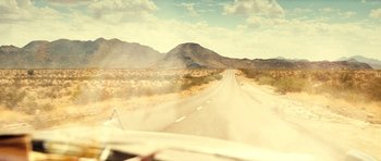 Movie still from “On the Road” (2012), directed by Walter Salles – A car driving down a dirt road in the middle of the desert; Extreme Wide shot, High angle