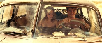 Movie still from “On the Road” (2012), directed by Walter Salles – A man and a woman driving a car in the road; Medium shot, High angle