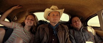 Movie still from “On the Road” (2012), directed by Walter Salles – A man in a cowboy hat sitting next to two other people in a car; Medium shot, Low angle