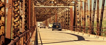 Movie still from “On the Road” (2012), directed by Walter Salles – A group of cars driving down a bridge; Extreme Wide shot, Low angle