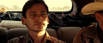 Movie still from “On the Road” (2012), directed by Walter Salles – A man sitting in the back seat of a car; Close Up shot, Over the shoulder angle