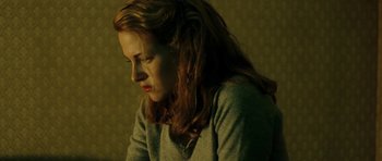 Movie still from “On the Road” (2012), directed by Walter Salles – A woman sitting in front of a wall looking down; Close Up shot, High angle