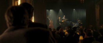 Movie still from “On the Road” (2012), directed by Walter Salles – A group of men playing music on a stage; Extreme Wide shot, Over the shoulder angle