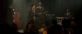 Movie still from “On the Road” (2012), directed by Walter Salles – A couple of people that are singing and playing music; Wide shot, High angle