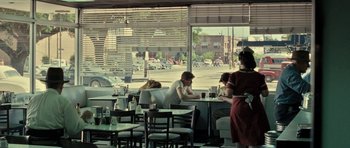 Movie still from “On the Road” (2012), directed by Walter Salles – People are sitting at a table in a restaurant; Wide shot, Over the shoulder angle