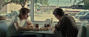 Movie still from “On the Road” (2012), directed by Walter Salles – Two people sitting at a table with a plate of food; Medium shot, Over the shoulder angle