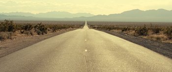 Movie still from “On the Road” (2012), directed by Walter Salles – An empty road in the middle of the desert; Extreme Wide shot, High angle