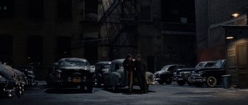 Movie still from “On the Road” (2012), directed by Walter Salles – A couple of men standing next to each other on a street; Wide shot, High angle