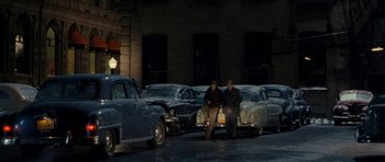 Movie still from “On the Road” (2012), directed by Walter Salles – A couple of men standing next to a row of old parked cars; Wide shot, High angle