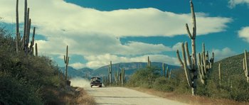 Movie still from “On the Road” (2012), directed by Walter Salles – A car driving down a dirt road near tall cacti; Extreme Wide shot, Low angle