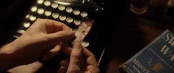 Movie still from “On the Road” (2012), directed by Walter Salles – A person is holding a picture of a man on top of an old typewriter; Extreme Close Up shot, High angle