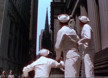 Movie still from “On the Town” (1949), directed by Gene Kelly – A group of sailors standing on the side of a tall building; Wide shot, Low angle