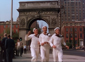 Movie still from “On the Town” (1949), directed by Gene Kelly – A group of men dressed in sailor outfits walking down a street; Wide shot, Low angle