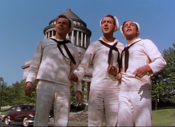 Movie still from “On the Town” (1949), directed by Gene Kelly – A group of men standing next to each other in sailor outfits; Wide shot, Low angle