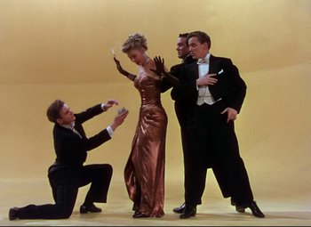 Movie still from “On the Town” (1949), directed by Gene Kelly – A group of people standing next to each other on a stage; Wide shot, High angle