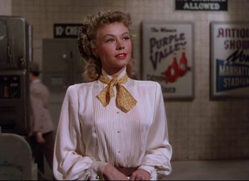Movie still from “On the Town” (1949), directed by Gene Kelly – A woman wearing a white shirt and a yellow bow tie; Medium shot, Low angle