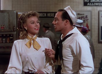Movie still from “On the Town” (1949), directed by Gene Kelly – A man and a woman standing next to each other; Medium shot, Low angle