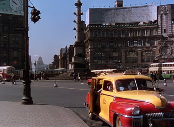 Movie still from “On the Town” (1949), directed by Gene Kelly – An old yellow and red car parked on the side of the street; Extreme Wide shot, Low angle