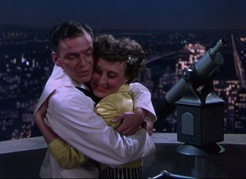 Movie still from “On the Town” (1949), directed by Gene Kelly – A man and a woman hugging in front of a telescope; Medium shot, Overhead angle