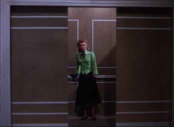 Movie still from “On the Town” (1949), directed by Gene Kelly – A woman standing in front of a door in a room; Wide shot, Low angle