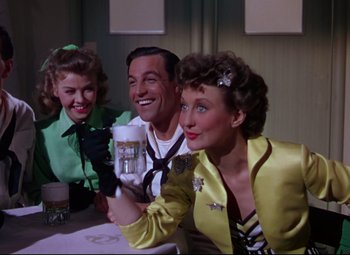 Movie still from “On the Town” (1949), directed by Gene Kelly – A man and two women sitting at a table; Medium shot, Low angle