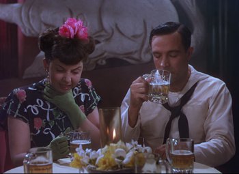Movie still from “On the Town” (1949), directed by Gene Kelly – A man and a woman sitting at a dinner table; Medium shot, High angle