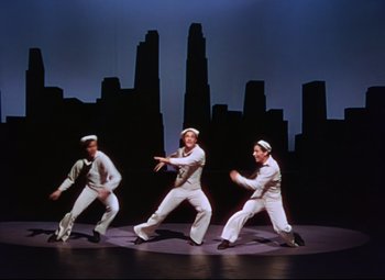 Movie still from “On the Town” (1949), directed by Gene Kelly – A group of men dressed in sailor outfits on a stage; Wide shot, High angle