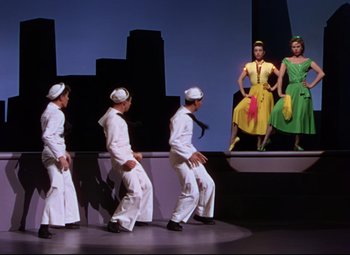 Movie still from “On the Town” (1949), directed by Gene Kelly – A group of men and women performing on a stage; Wide shot, Low angle