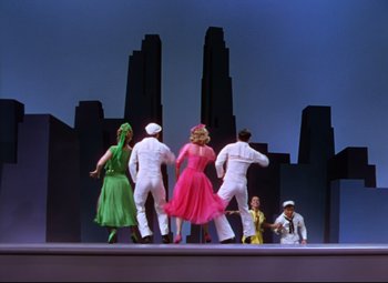 Movie still from “On the Town” (1949), directed by Gene Kelly – A group of people standing on top of a stage; Wide shot, Low angle