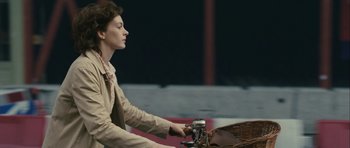 Movie still from “One Day” (2011), directed by Lone Scherfig – A woman riding a bike with a basket on the back of it; Medium shot, Over the shoulder angle