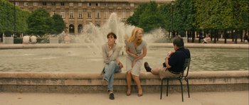 Movie still from “One Day” (2011), directed by Lone Scherfig – Two women and a man sitting in front of a fountain; Wide shot, Over the shoulder angle