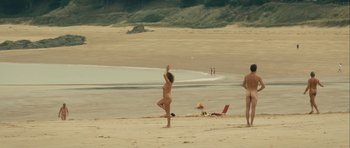 Movie still from “One Day” (2011), directed by Lone Scherfig – Two women on the beach playing a game of frisbee; Extreme Wide shot, High angle
