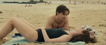 Movie still from “One Day” (2011), directed by Lone Scherfig – A man and a woman laying on the beach; Medium shot, High angle
