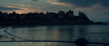 Movie still from “One Day” (2011), directed by Lone Scherfig – A body of water at night with a city in the background; Extreme Wide shot, High angle