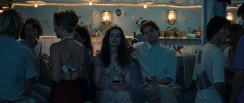 Movie still from “One Day” (2011), directed by Lone Scherfig – A man and a woman sitting next to each other holding wine glasses; Medium shot, Over the shoulder angle
