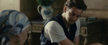 Movie still from “One Day” (2011), directed by Lone Scherfig – A man in a white t - shirt and a black vest; Medium shot, Over the shoulder angle