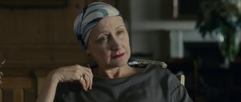 Movie still from “One Day” (2011), directed by Lone Scherfig – An older woman wearing a head scarf looking at the camera; Close Up shot, Over the shoulder angle