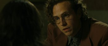 Movie still from “One Day” (2011), directed by Lone Scherfig – A person wearing glasses and a suit; Close Up shot, Over the shoulder angle