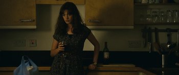 Movie still from “One Day” (2011), directed by Lone Scherfig – A woman holding a wine glass in a kitchen; Medium shot, Over the shoulder angle