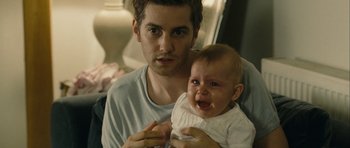 Movie still from “One Day” (2011), directed by Lone Scherfig – A man holding a crying baby in his arms; Close Up shot, Over the shoulder angle