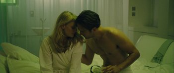 Movie still from “One Day” (2011), directed by Lone Scherfig – A man and a woman in a room with curtains; Medium shot, High angle
