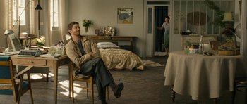 Movie still from “One Day” (2011), directed by Lone Scherfig – A man sitting on a chair in a living room; Wide shot, Over the shoulder angle