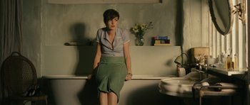Movie still from “One Day” (2011), directed by Lone Scherfig – A woman sitting on top of a bench in front of a sink; Medium shot, Over the shoulder angle