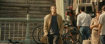 Movie still from “One Day” (2011), directed by Lone Scherfig – A man in a trench coat standing next to a staircase; Medium shot, Over the shoulder angle