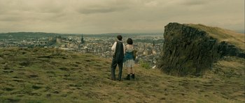 Movie still from “One Day” (2011), directed by Lone Scherfig – A man and a woman standing on top of a hill looking at a city; Extreme Wide shot, High angle